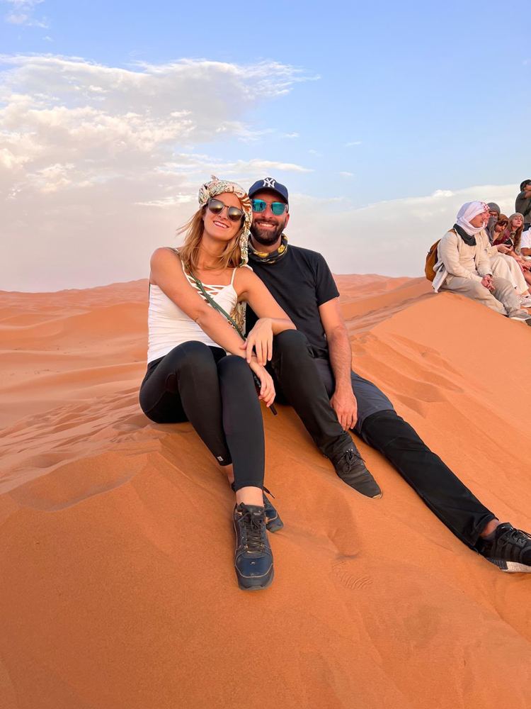 Greta e Andrea seduti su una duna in Marocco